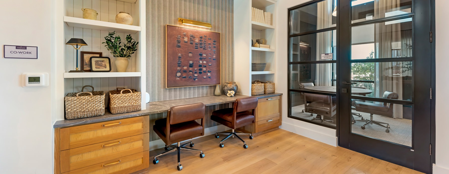 desk with two chairs and a painting on the wall